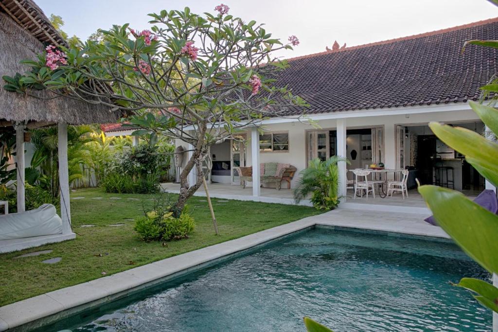a villa with a swimming pool in front of a house at Villa Tom & Lucie Bingin Beach in Uluwatu