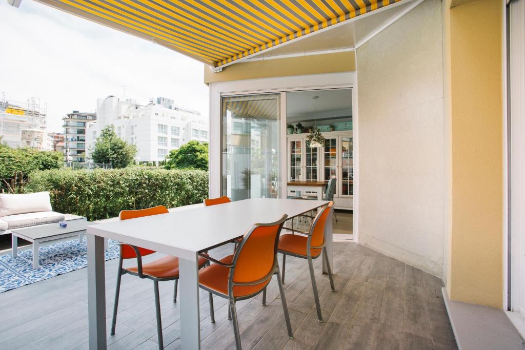 サン・セバスティアンにあるOndarreta Villa Apartmentのダイニングルーム(白いテーブル、オレンジの椅子付)
