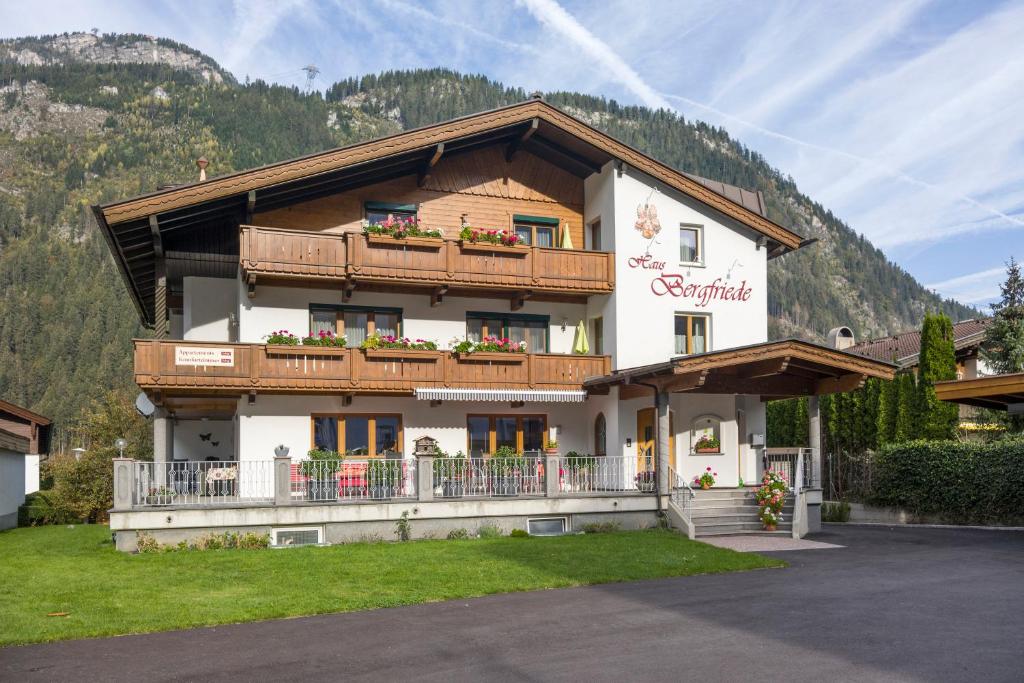 a large building with a balcony and a mountain at Haus Bergfriede in Mayrhofen