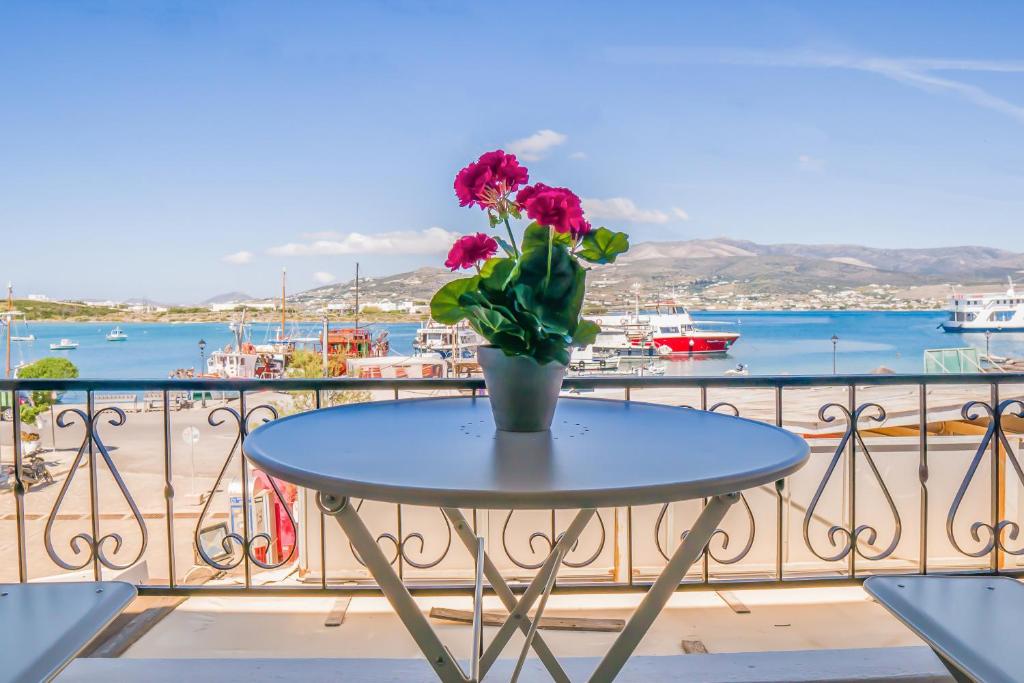 a vase of flowers sitting on a table on a balcony at Limani in Antiparos