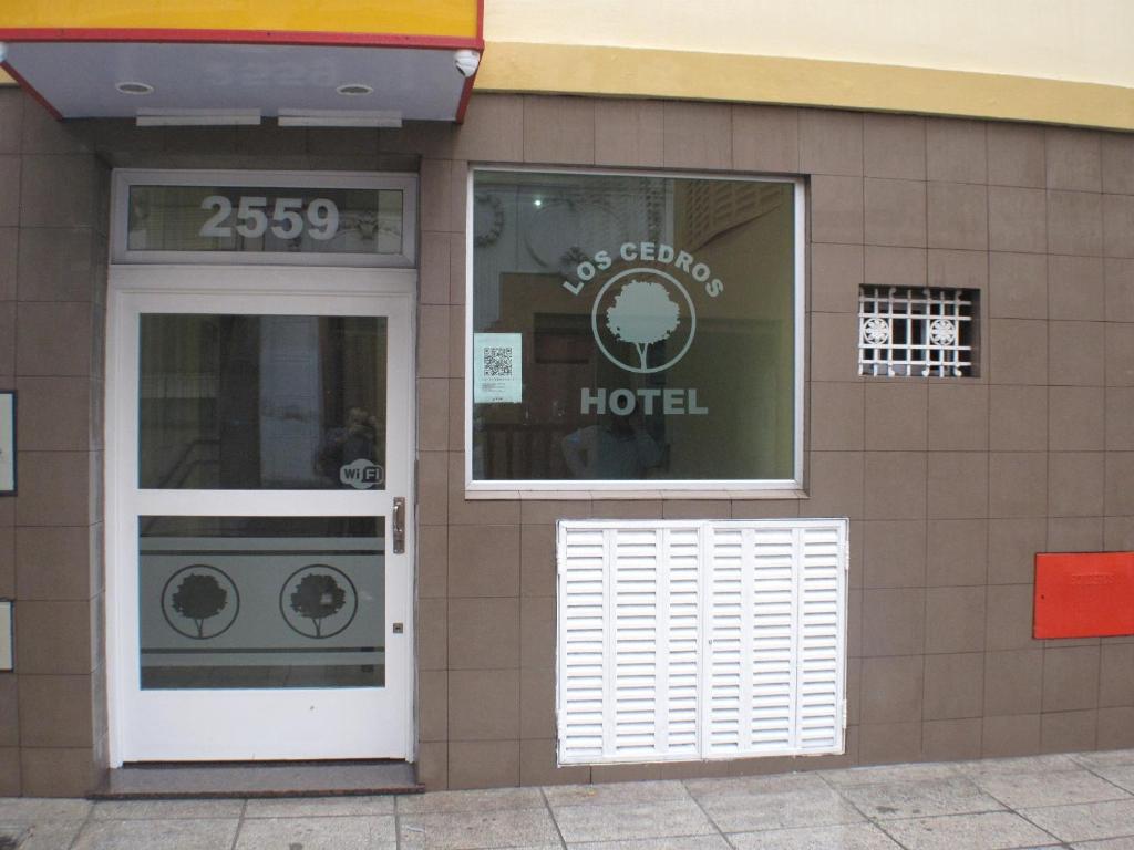 a door to a hotel with a sign on it at Hotel Los Cedros in Buenos Aires