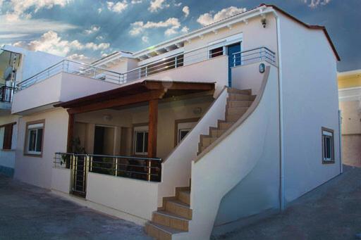 a white house with stairs on the side of it at JORGO in Kremasti
