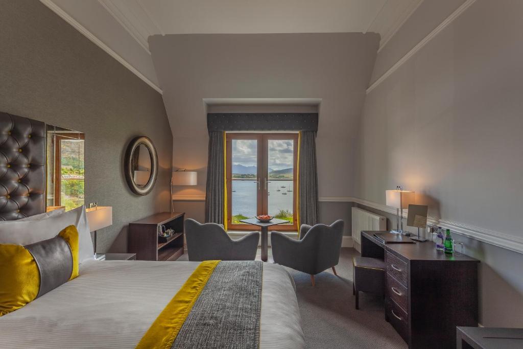 una camera d'albergo con letto, scrivania e sedie di Cuillin Hills Hotel a Portree