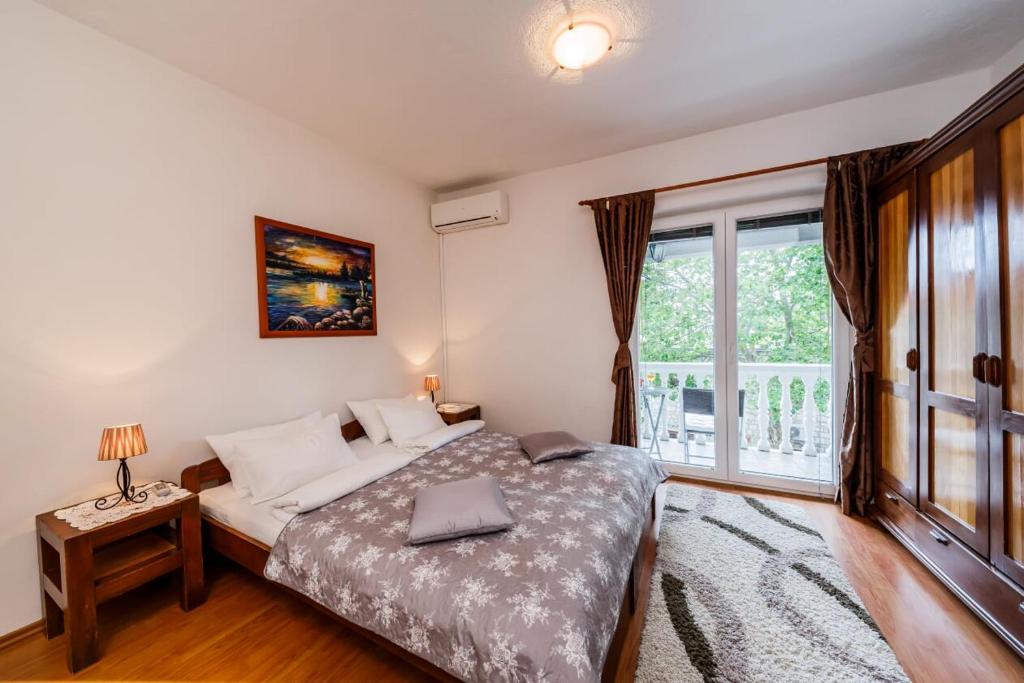 1 dormitorio con cama y ventana grande en Maria Guest House en Kaštela