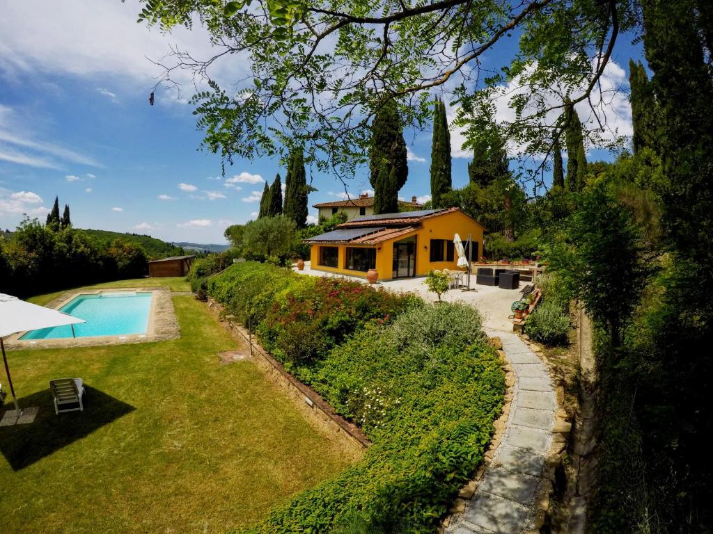a house with a swimming pool in front of a yard at Il Caldio in San Casciano in Val di Pesa