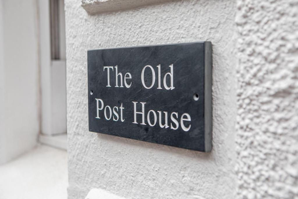 Un cartello che legge il vecchio ufficio postale su un muro di The Old Post House a Kyle of Lochalsh