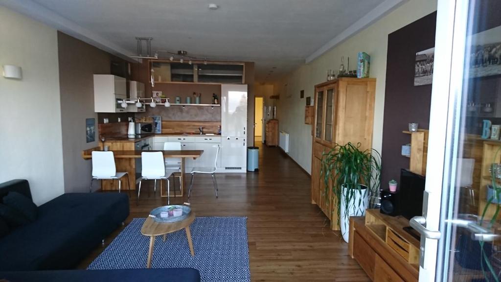 ein Wohnzimmer und eine Küche mit einem Sofa und einem Tisch in der Unterkunft Alpentraum in Scheidegg