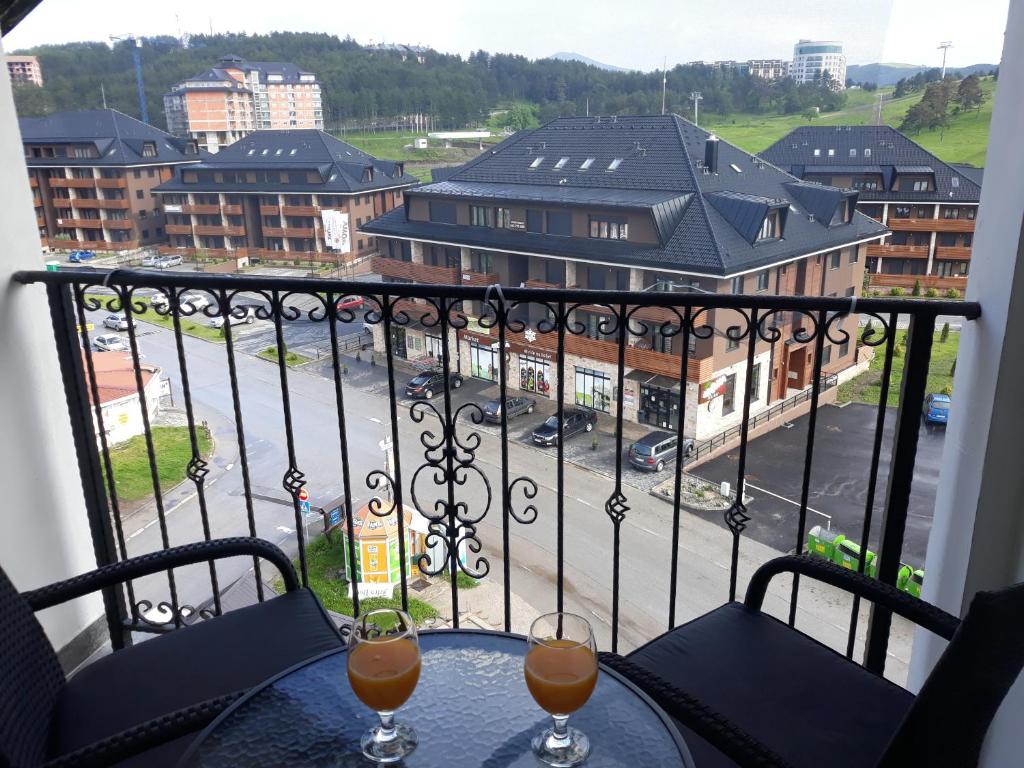 ein Tisch mit zwei Gläsern Wein auf einem Balkon in der Unterkunft Pejzaž Zlatibora in Zlatibor