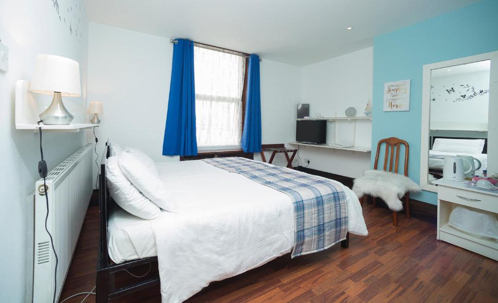 a bedroom with a white bed and a mirror at Breeze Guest House in Bootle