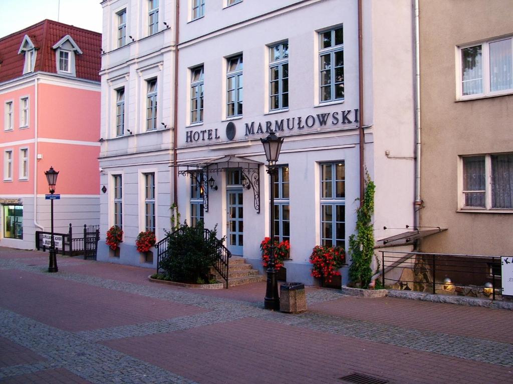 a large brick building with a clock on the front of it at Hotel Marmułowski in Wejherowo