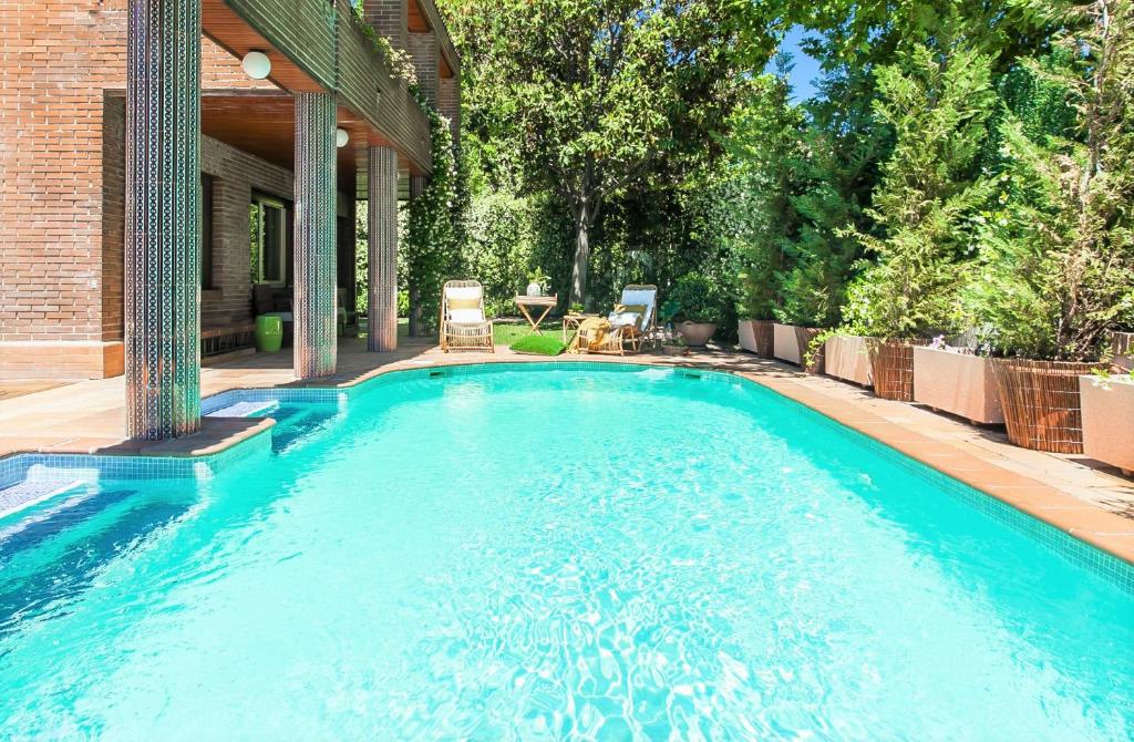 a swimming pool in the backyard of a house at Velazquez Manor House in Madrid