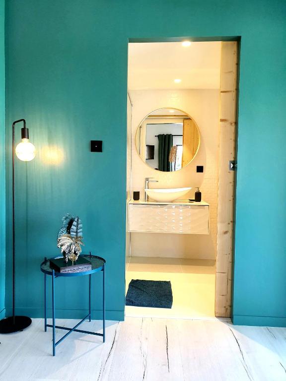 a bathroom with a table and a mirror at Les Granges de Jules in Lafitte-Vigordanne