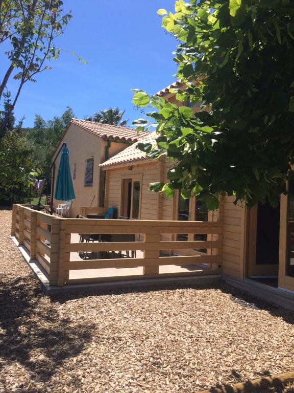 a wooden fence in front of a house at Gîte le châlet des milles et un chemins in Castelnou