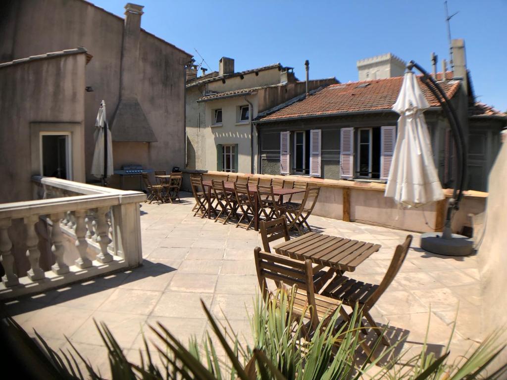 a group of chairs and an umbrella on a patio at A l'ombre du Palais in Avignon