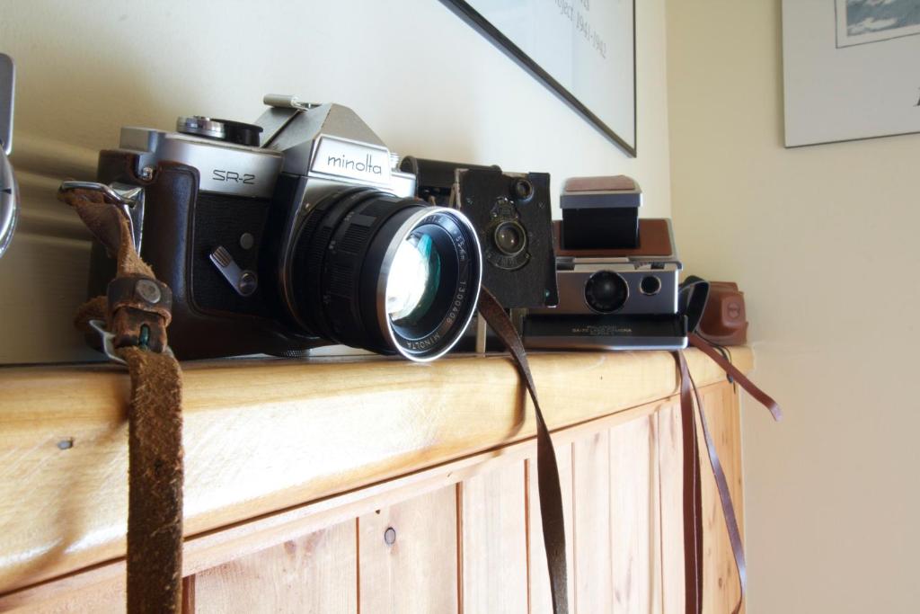 a camera sitting on top of a wooden dresser at Auberge Le Lupin-Self Check-in in Mont-Tremblant