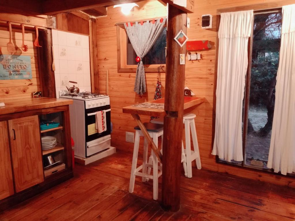 a kitchen with a stove and a counter in a cabin at El Canto de la Ballena in Puerto Pirámides