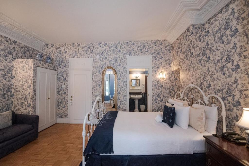 a bedroom with a bed and a couch at Manoir Sherbrooke in Montréal