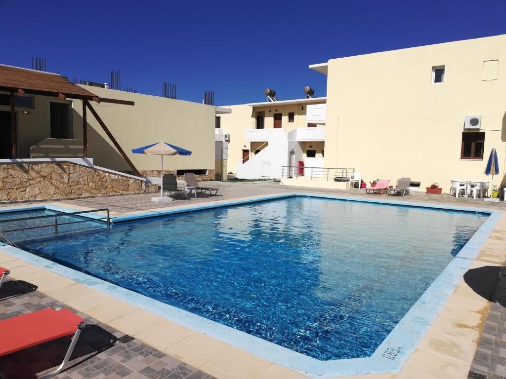 a large swimming pool in front of a building at Karmi Apartments in Kolymvari