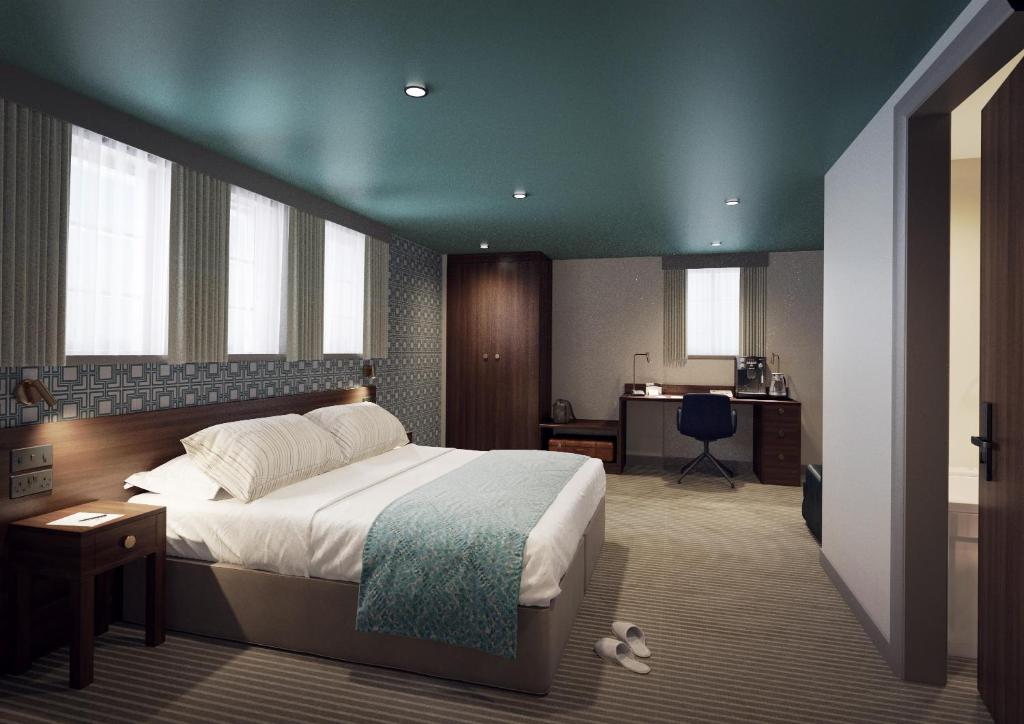 ein Schlafzimmer mit einem großen Bett und einem Schreibtisch in der Unterkunft The Comet London Hatfield in Hatfield