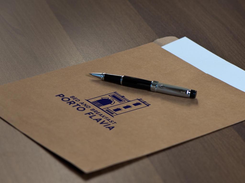 a pen is sitting on top of a envelope at Bed and Breakfast Porto Flavia in Iglesias