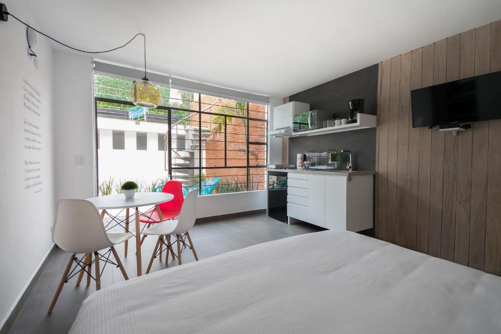 een slaapkamer met een bed en een tafel en stoelen bij JUUB New Beautiful Suite Nuevo Polanco (R2) in Mexico-Stad
