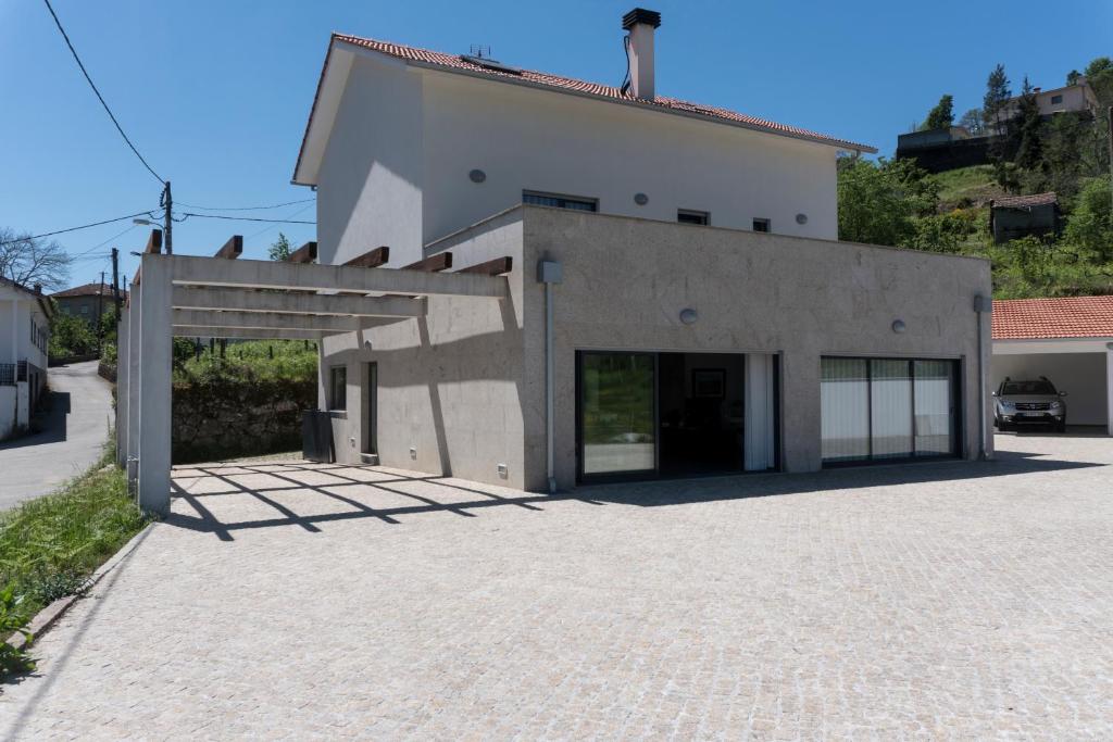 a large white building with a large garage at Casa Guarda Rios - São Pedro do Sul in São Pedro do Sul