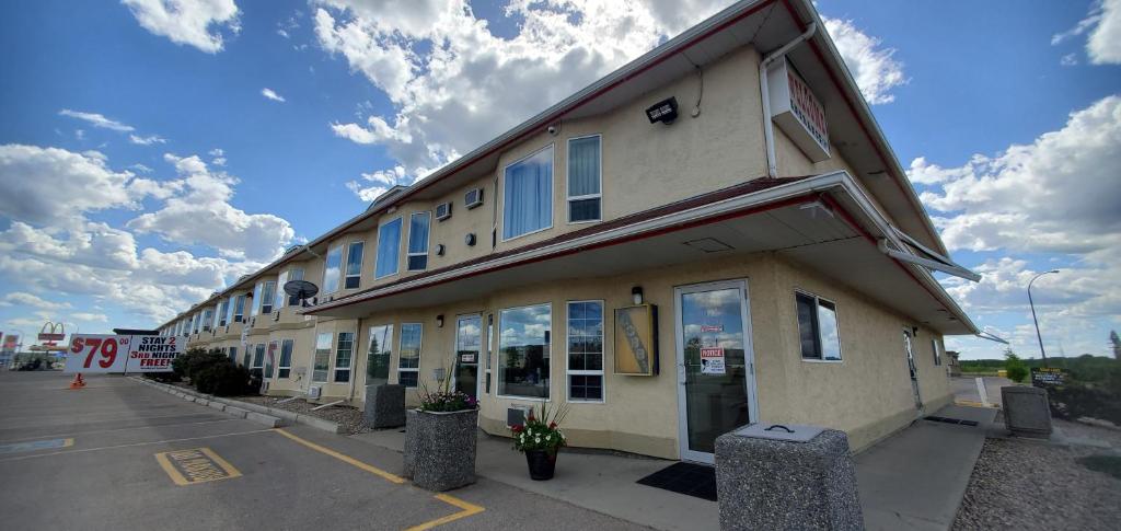 a building with blue windows in a parking lot at Western Budget Motel Cold Lake in Cold Lake