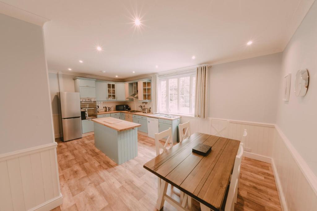 uma cozinha com uma mesa de madeira e um piso de madeira em Owners Residence em Wales