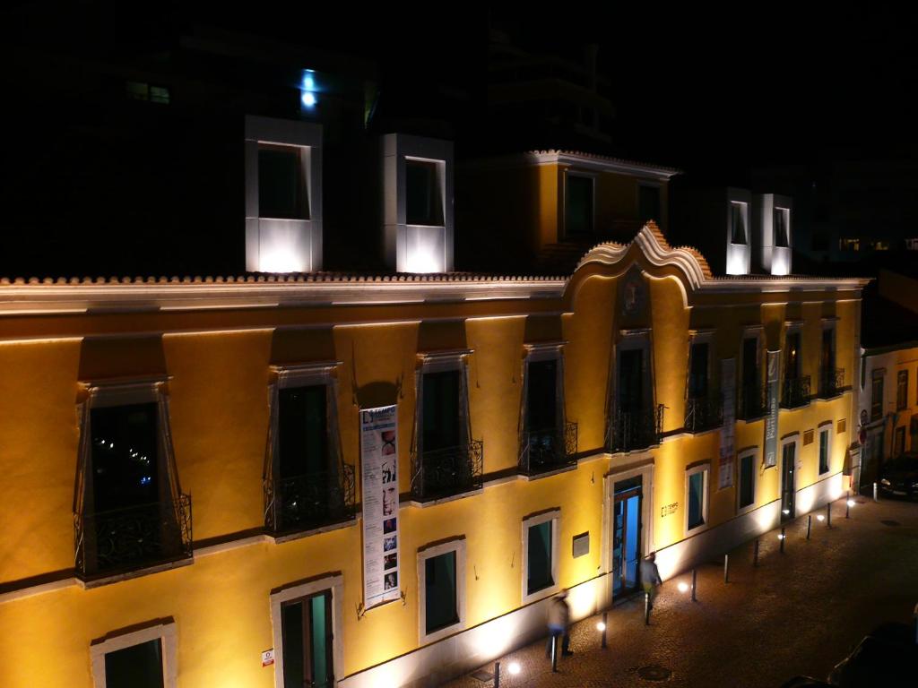 een gebouw met lichten aan de zijkant 's nachts bij Temple Suites Guesthouse in Portimão