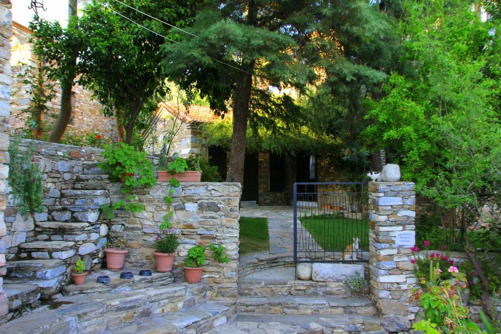 a stone wall with potted plants in a garden at Eski Doganbey Houses in Doğanbey