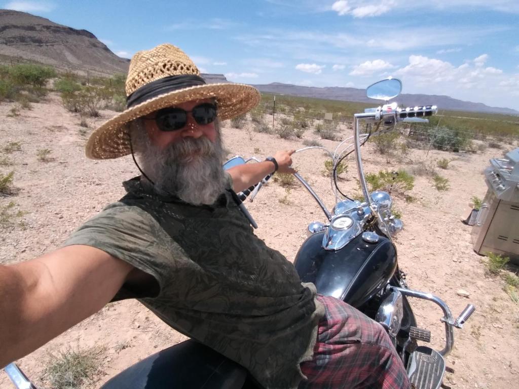 een man met een hoed op een motor in de woestijn bij Camping at Desert Gardens Oasis at Lobo, Texas in Van Horn