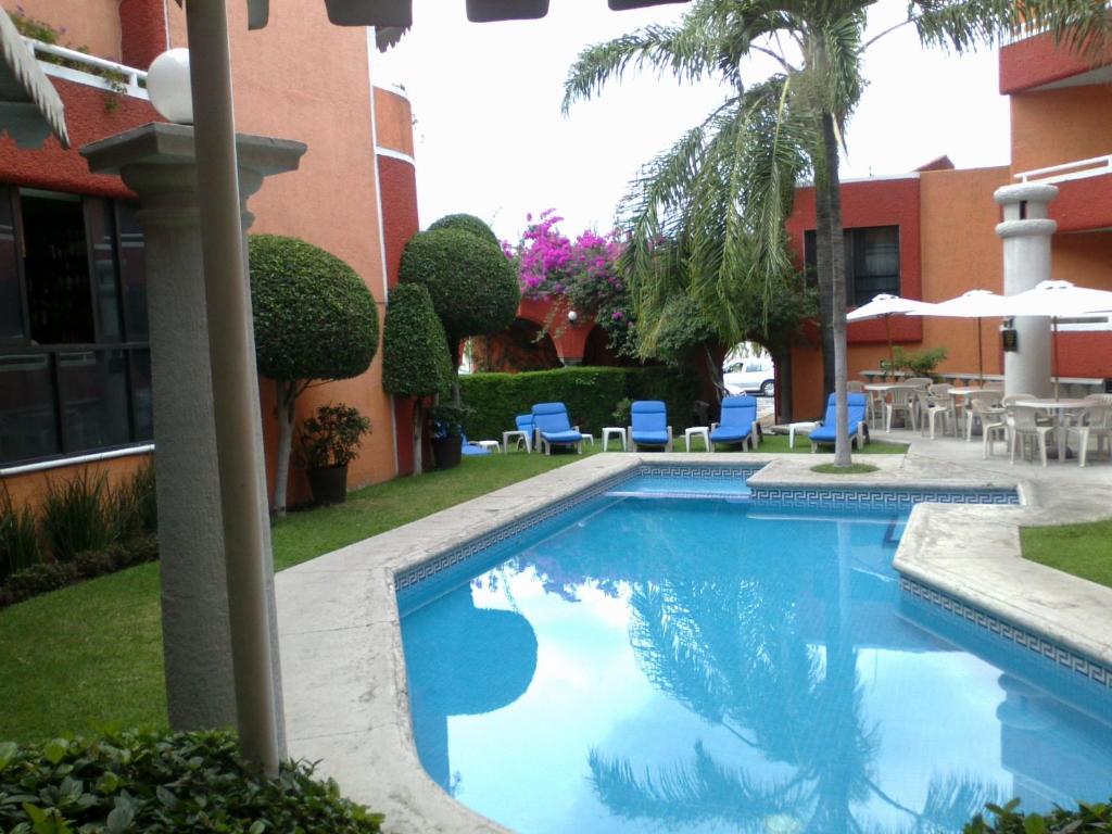a swimming pool in front of a building at Hotel Real del Sol in Cuernavaca