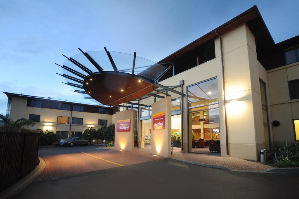 un edificio iluminado con un cartel delante en Heartland Hotel Auckland Airport en Auckland