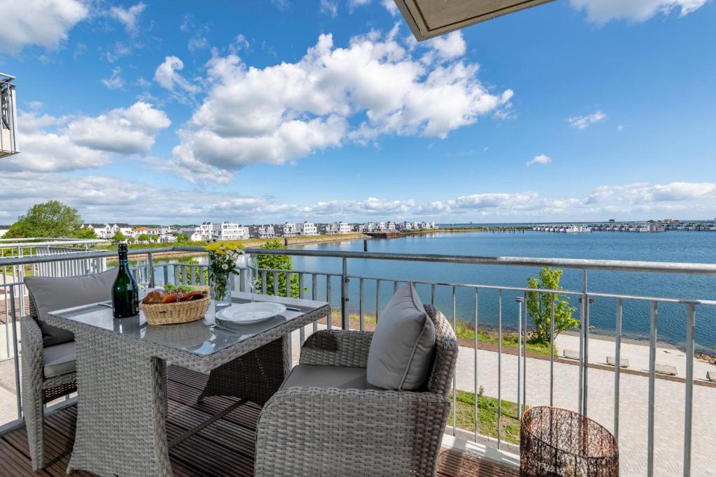 a balcony with a table and chairs and a view of the water at Enjoy in Olpenitz