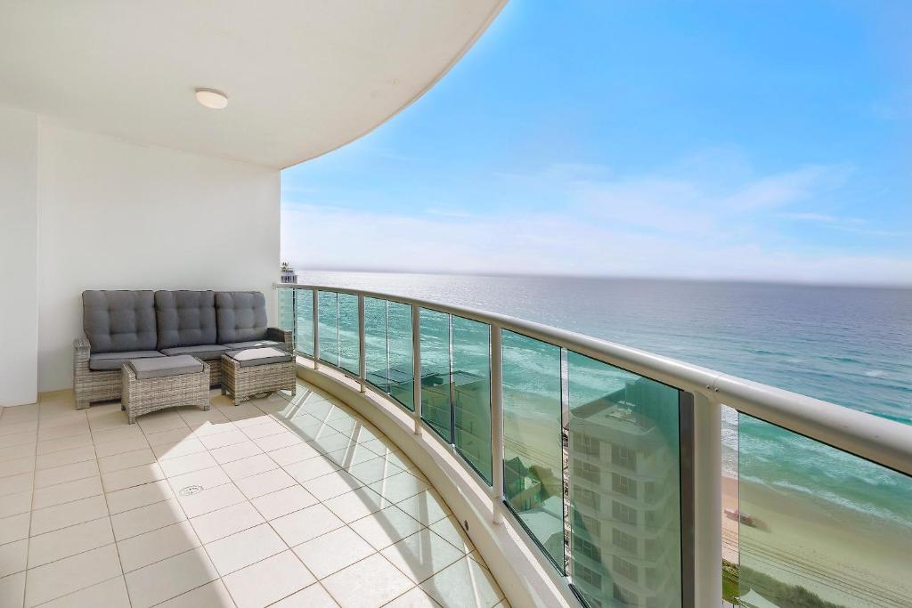 a balcony with a chair and the ocean at Pacific Views Resort in Gold Coast