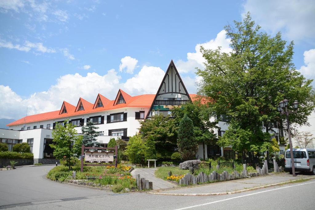 a large white building with a pointed roof at Kurobe Kanko Hotel in Omachi