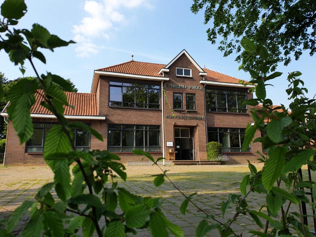 een groot bakstenen gebouw met veel ramen bij B&B de Wilhelminaschool in Aalten
