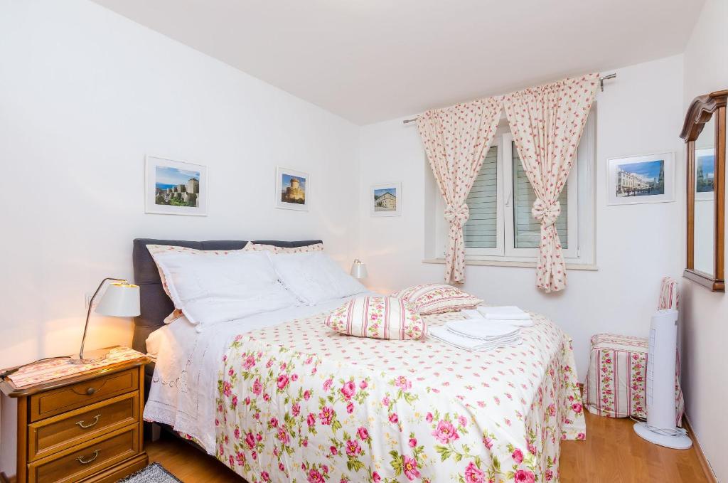 a bedroom with a bed and a window at Apartments Captain in Dubrovnik