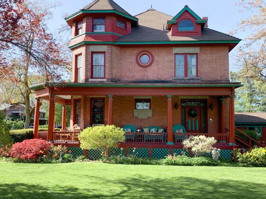 ein großes Haus mit Stühlen auf der Veranda in der Unterkunft Guest Suite at The Red House basement attached with private entrance in Salt Lake City