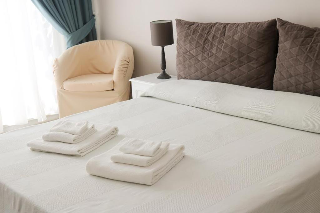 ein weißes Bett mit zwei weißen Handtüchern darauf in der Unterkunft Gabri Holiday House in Catania
