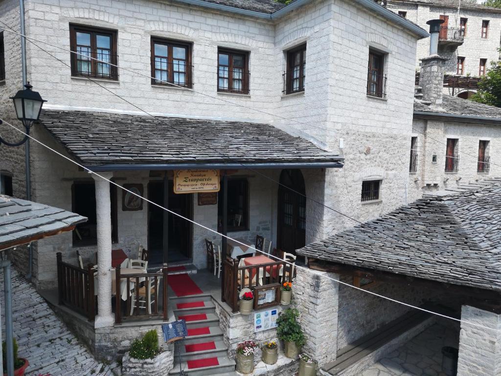 an old stone building with a porch and a balcony at Stavraetos in Syrrako