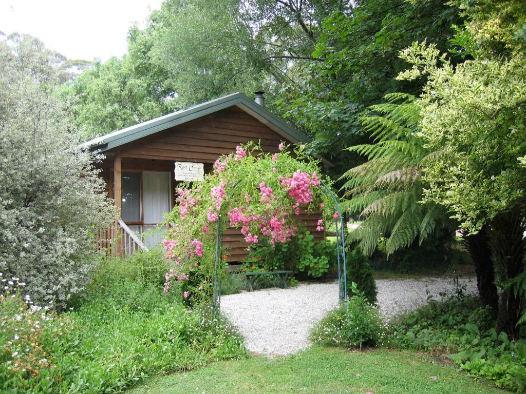 a garden with a wooden shed with flowers on it at RiverCottage-selfcontained in Marysville