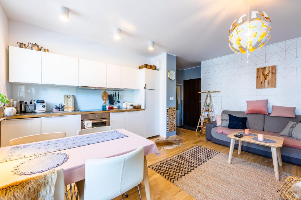 kuchnia i salon ze stołem i kanapą w obiekcie Apartament Vanilla w mieście Gdynia