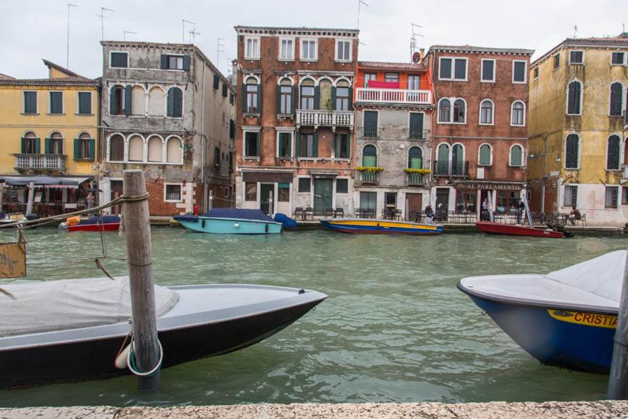a group of boats in a canal with buildings at La Colombina in Venice
