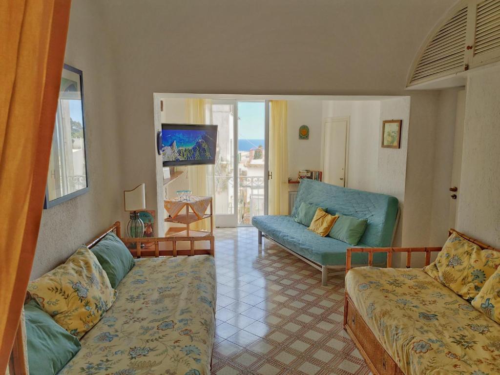 een woonkamer met een bank en een stoel bij Caprihouse in Capri