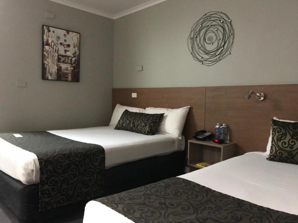 Postel nebo postele na pokoji v ubytování Burnie Central Townhouse Hotel