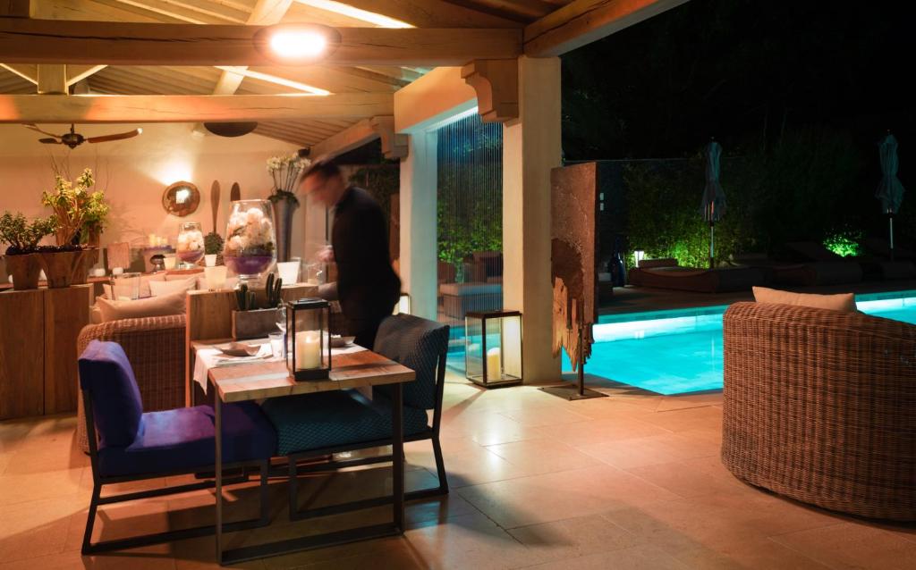 a man standing in a living room with a table at Le Pre de la Mer in Saint-Tropez