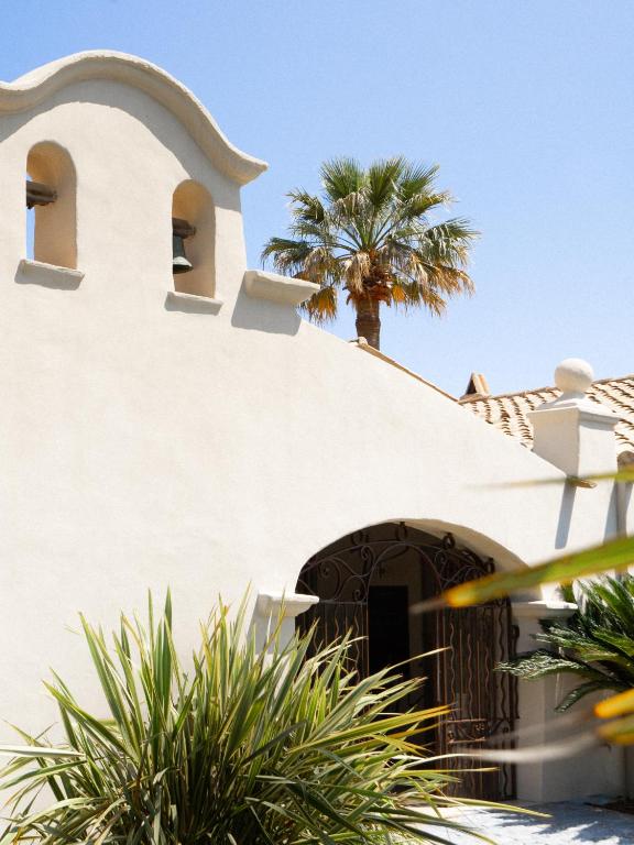 a white building with a palm tree on top of it at Le Pre de la Mer in Saint-Tropez