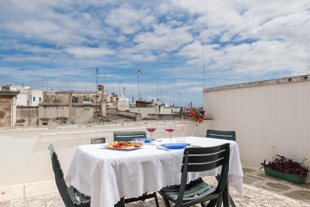 a table with glasses of wine on a balcony at Terrazza Primavera by Wonderful Italy in Ostuni