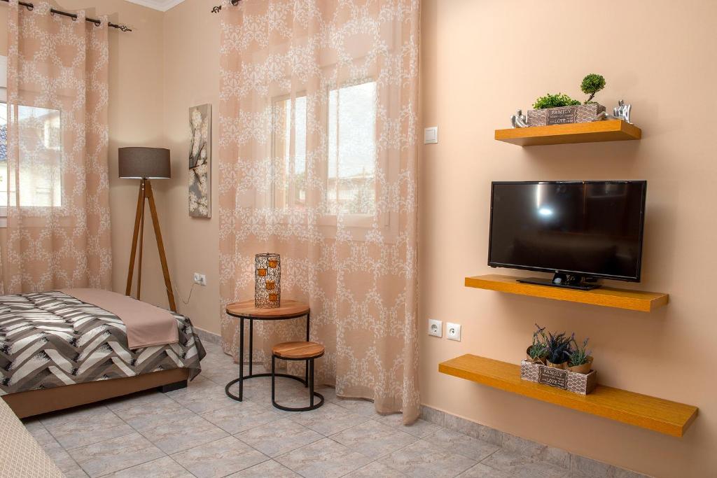 a room with a tv and a bed and a window at Chrysa Apartment in Makrygialos